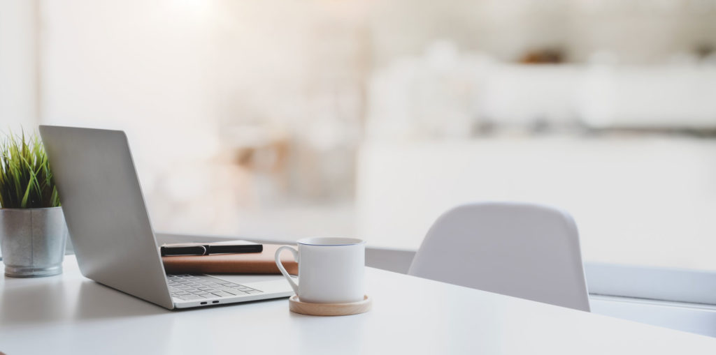 Schreibtisch mit Laptop und Kaffeetasse